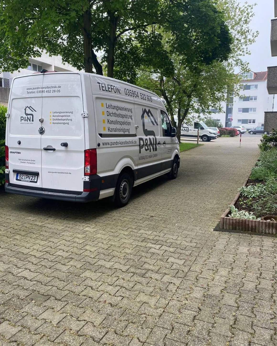 Firmenwagen von P&N zwischen den Häusern einer Wohnanlage